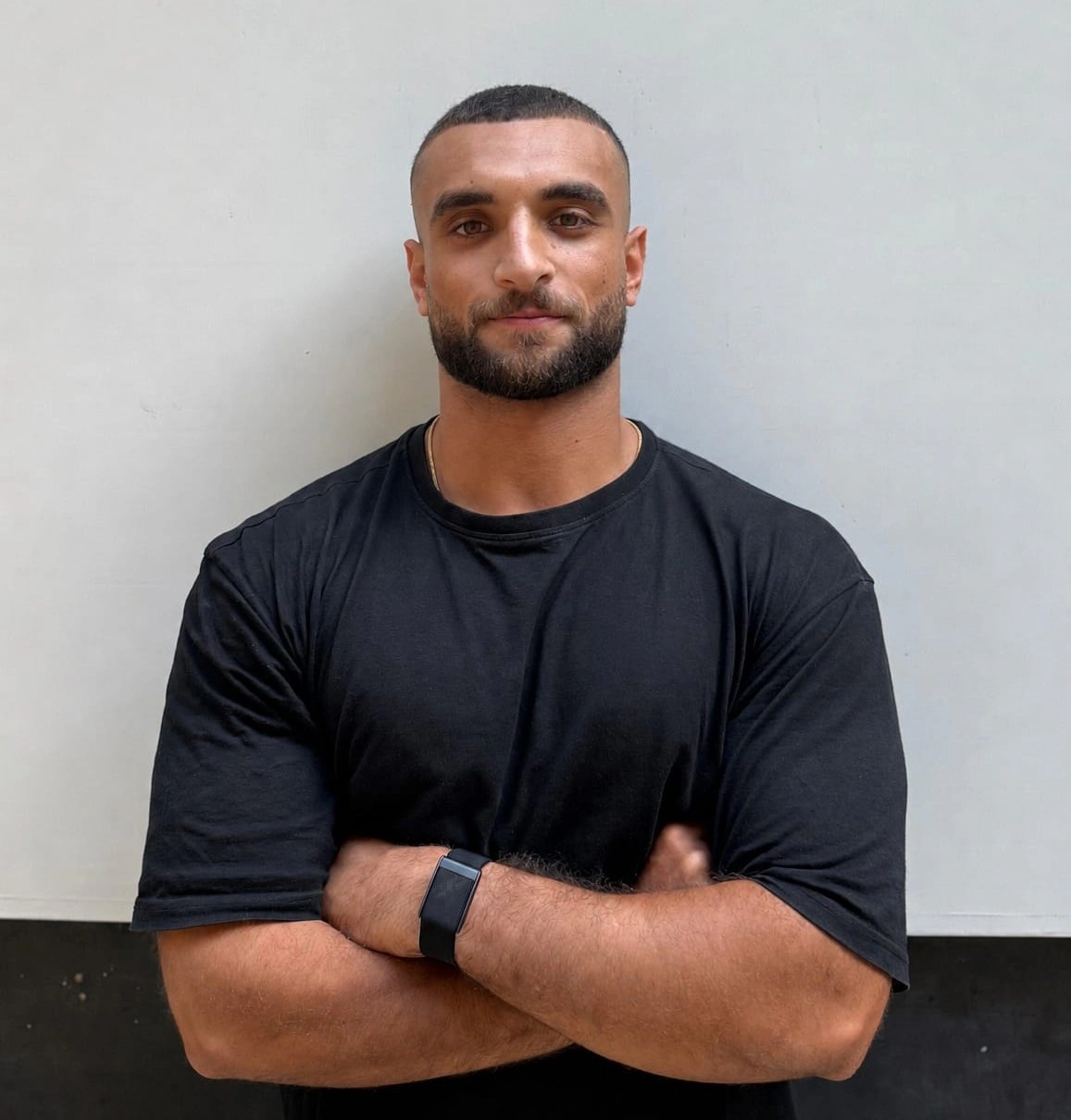 Ramez Asaad in a black t-shirt, arms crossed