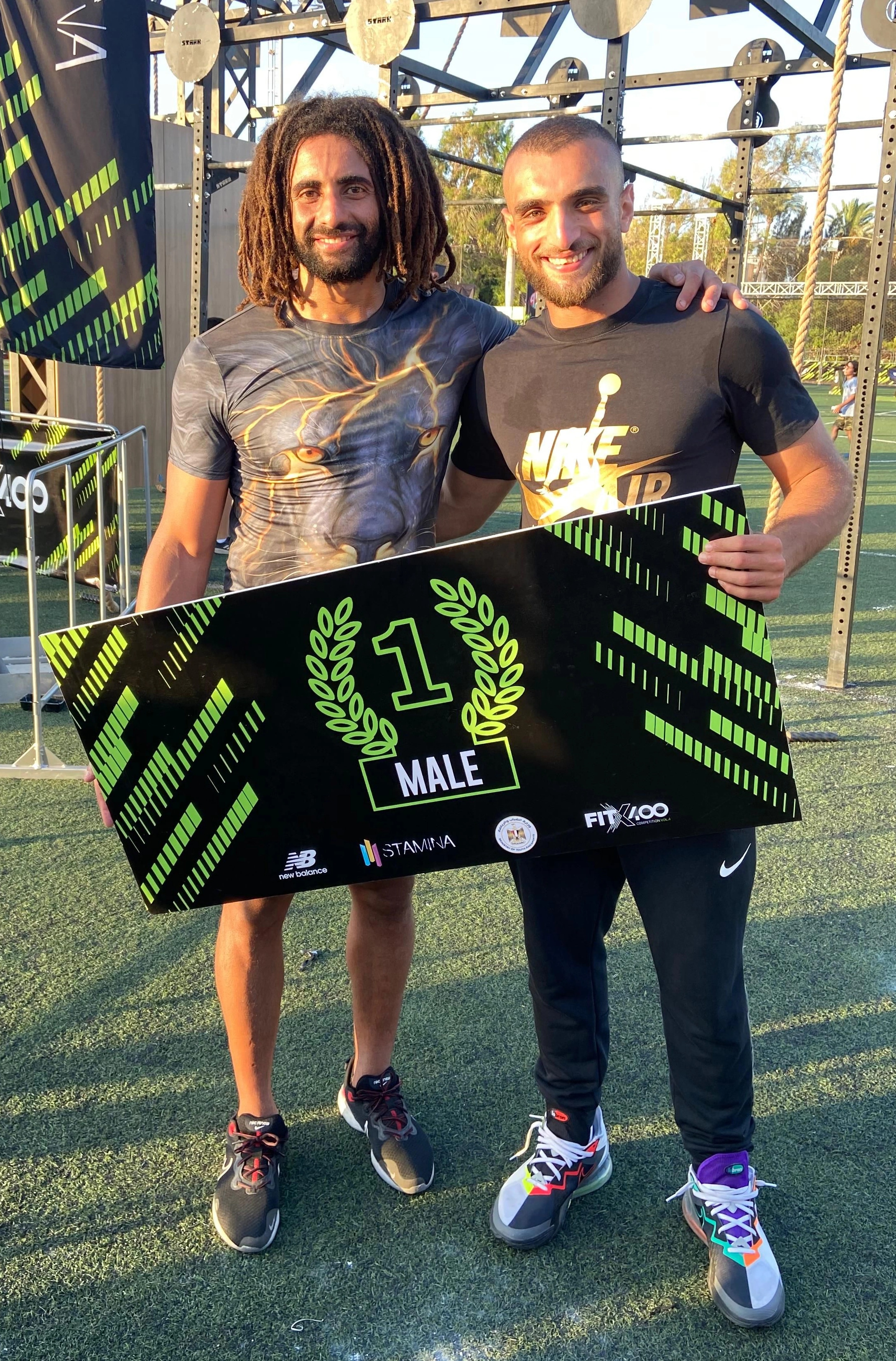 Ramez Asaad holding a first-place sign at FitX100