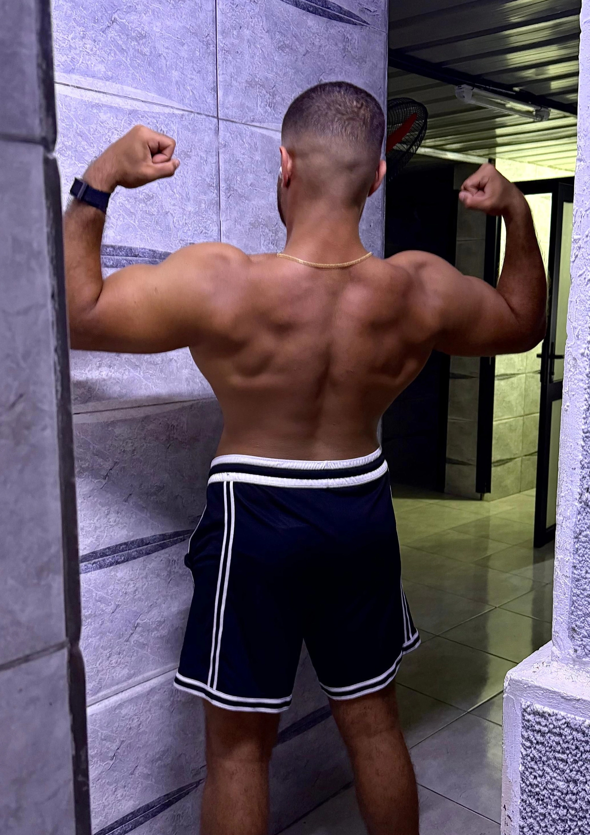 Ramez Asaad from behind, flexing a lean, muscular back