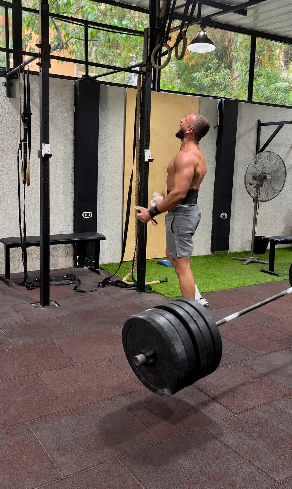 Ramez Asaad, belted and chalked, roaring after dropping a heavy deadlift in the gym