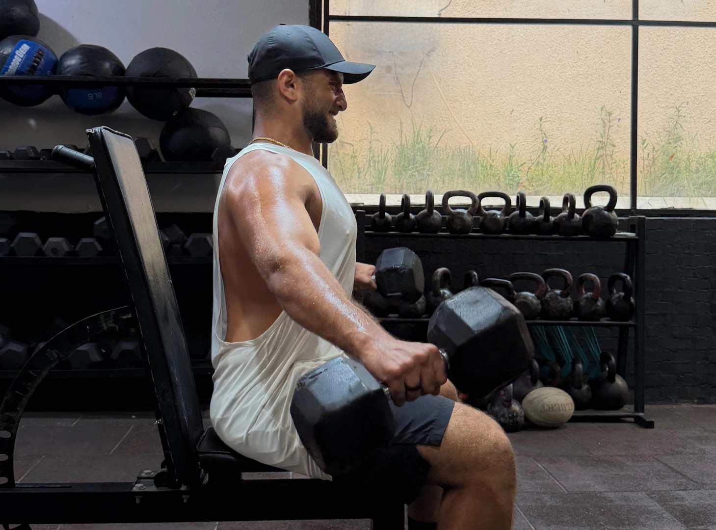 Ramez Asaad doing a seated dumbbell press in the gym